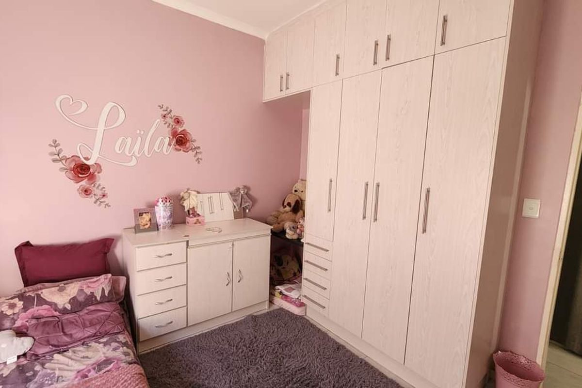 A bedroom featuring extensive built-in wardrobe storage and cabinetry, providing ample space for organization and storage.
