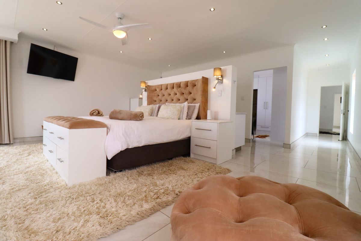 Spacious bedroom featuring tiled flooring, recessed ceiling lighting, a ceiling fan, and a partition wall creating a semi-private dressing or walk-in closet area.