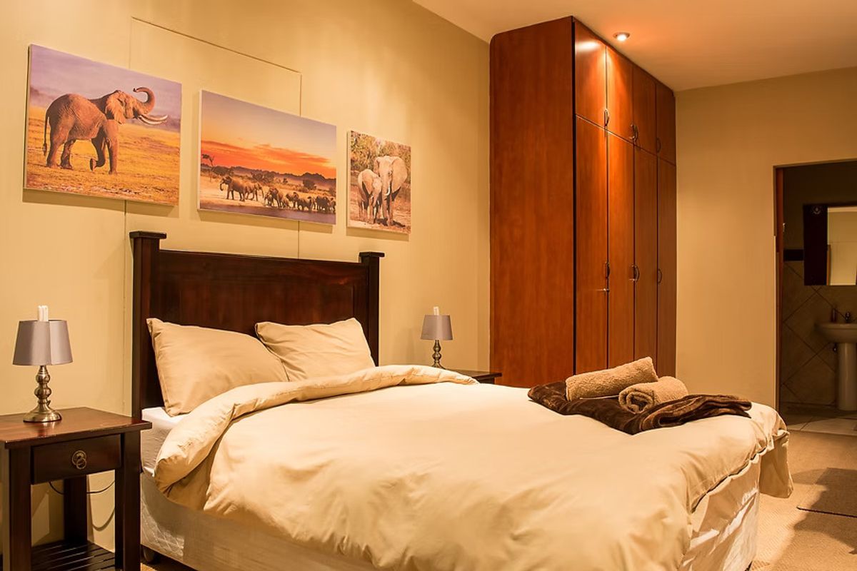 A well-maintained bedroom featuring built-in wooden cabinetry and an en-suite bathroom access, providing a comfortable and functional guest accommodation space.