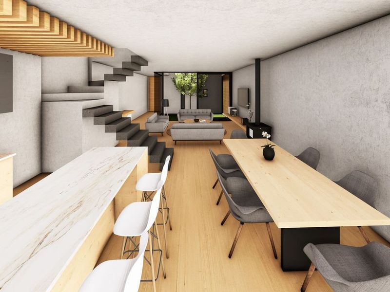 Modern open-plan living area featuring a marble kitchen island, floating staircase, timber ceiling accents, and a wood-burning fireplace leading to a rear patio.