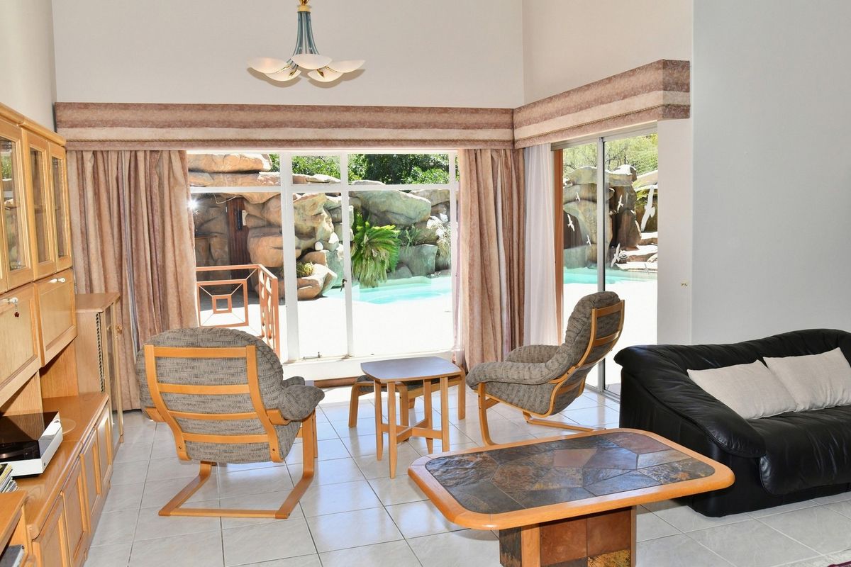 Spacious living room featuring large sliding glass doors that provide direct access and views to the outdoor pool area.