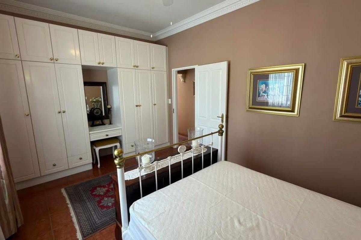 A bedroom featuring extensive built-in cabinetry with an integrated vanity, crown molding, and tiled flooring.