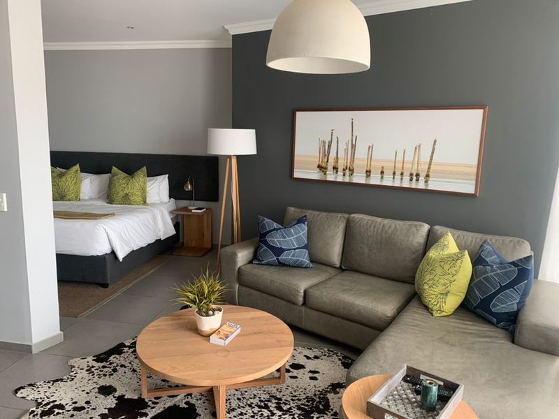 An open-plan studio apartment featuring a combined living area and bedroom space with modern finishes and neutral wall tones.