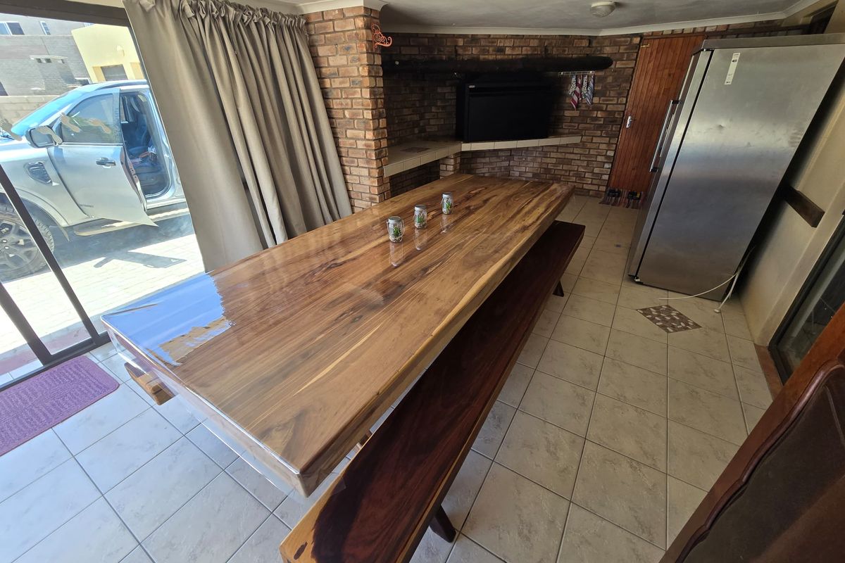 An indoor entertainment area featuring a built-in brick fireplace, tiled flooring, and sliding glass doors providing direct access to the exterior.