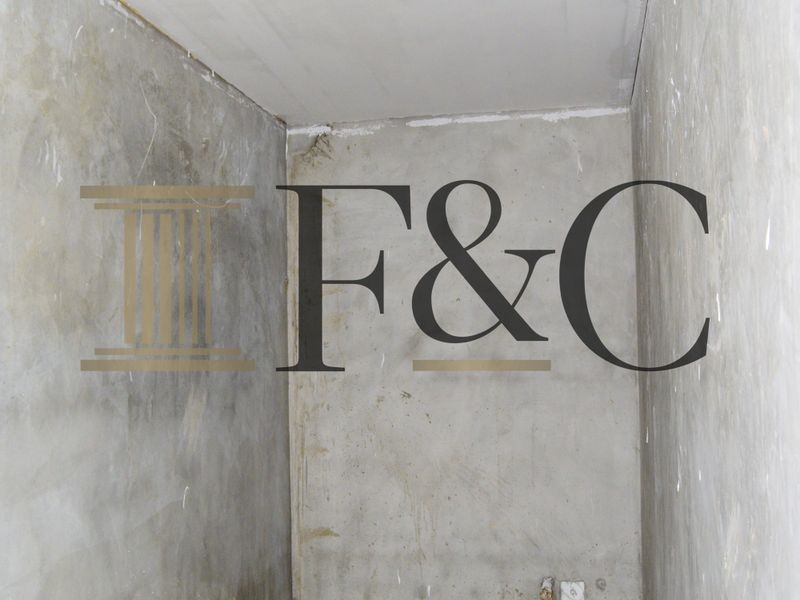 An unfinished interior space featuring raw concrete walls and floor with visible electrical and plumbing rough-ins, suitable for renovation.