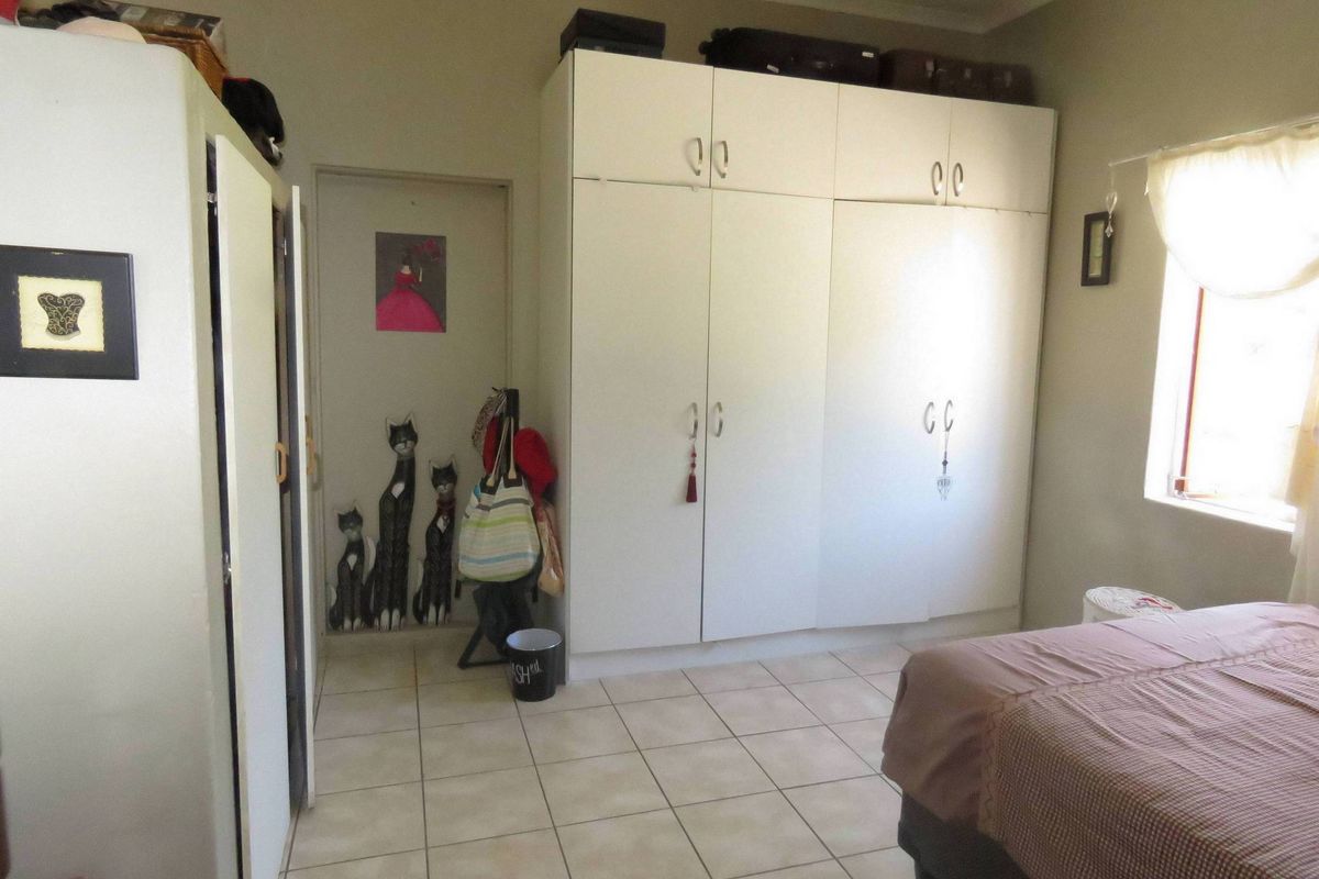 Bedroom featuring built-in white cabinetry and tiled flooring, providing functional storage space.