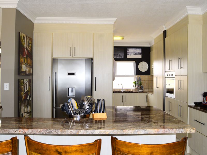 A well-appointed kitchen featuring granite countertops, ample built-in cabinetry, and integrated appliances, offering a functional and organized culinary space.