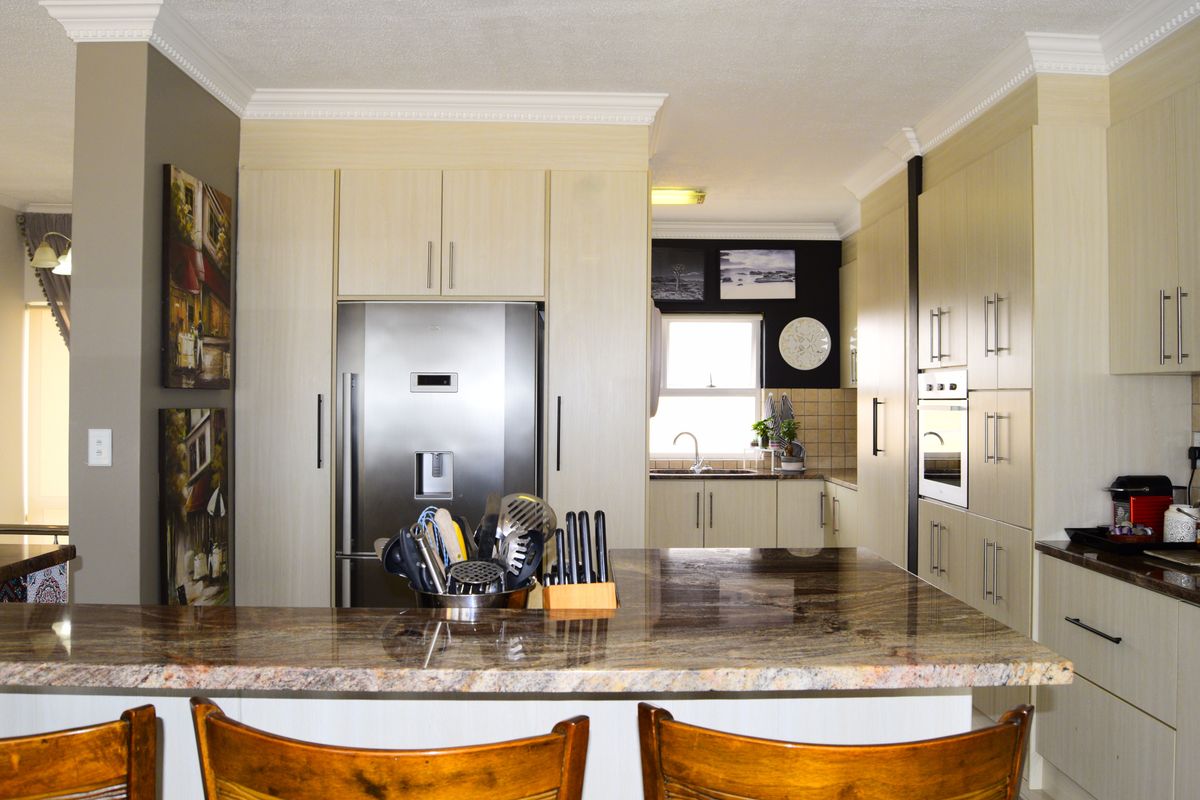 A well-appointed kitchen featuring granite countertops, ample built-in cabinetry, and integrated appliances, offering a functional and organized culinary space.