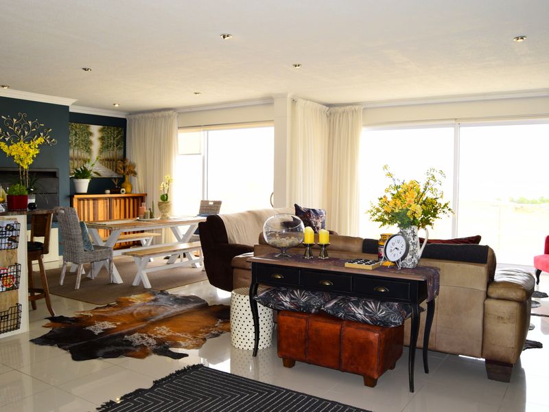 Spacious open-plan living and dining area featuring tiled floors, recessed lighting, and large sliding glass doors that provide ample natural light.