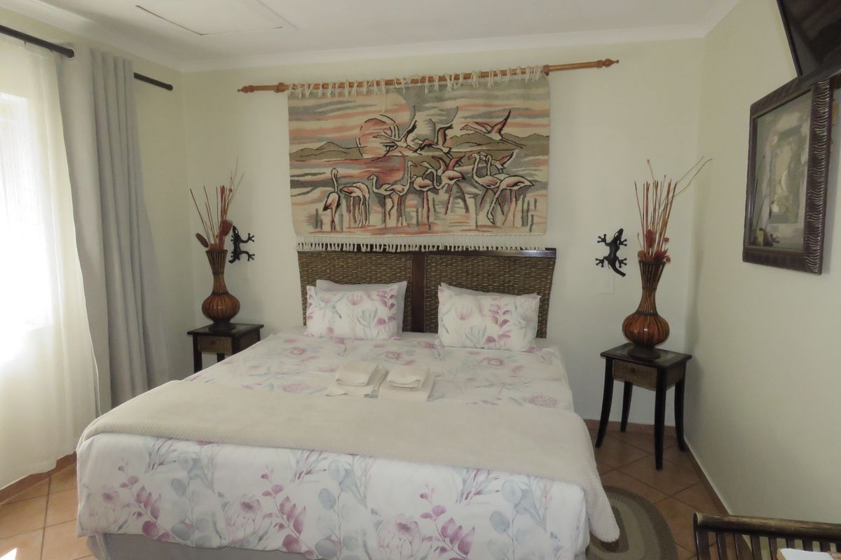 A well-maintained bedroom featuring tiled flooring and neutral wall finishes, providing a comfortable and functional sleeping space.