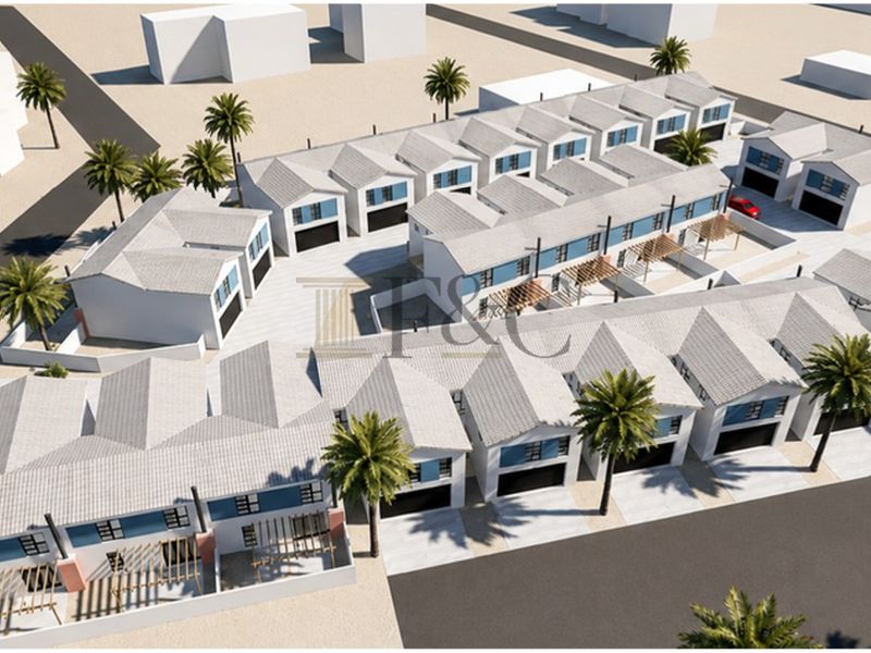 Aerial perspective of a modern townhouse development featuring multiple units with pitched roofs, integrated garages, and paved outdoor areas.
