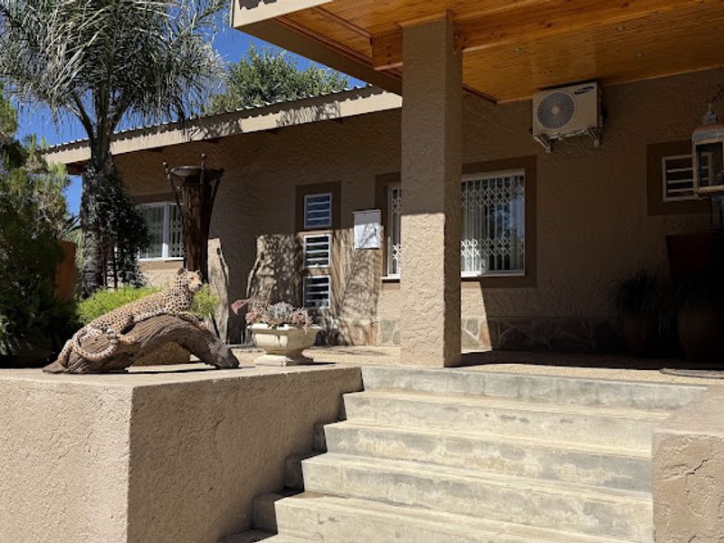 A covered patio area featuring a timber ceiling, concrete steps, and exterior stone cladding details.
