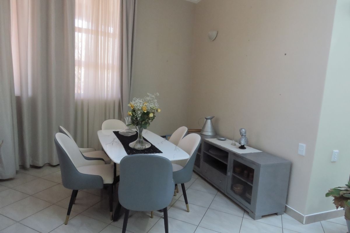A bright dining area featuring tiled flooring, neutral wall tones, and elegant cove cornicing, providing a clean and functional space for meals.