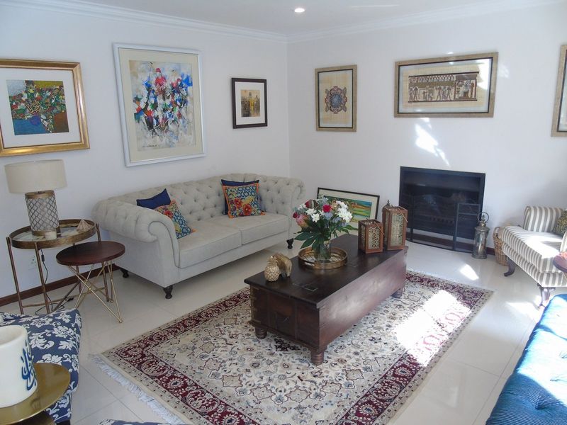 A well-maintained living room featuring tiled flooring, a built-in fireplace, and decorative coving, creating a comfortable and inviting space.