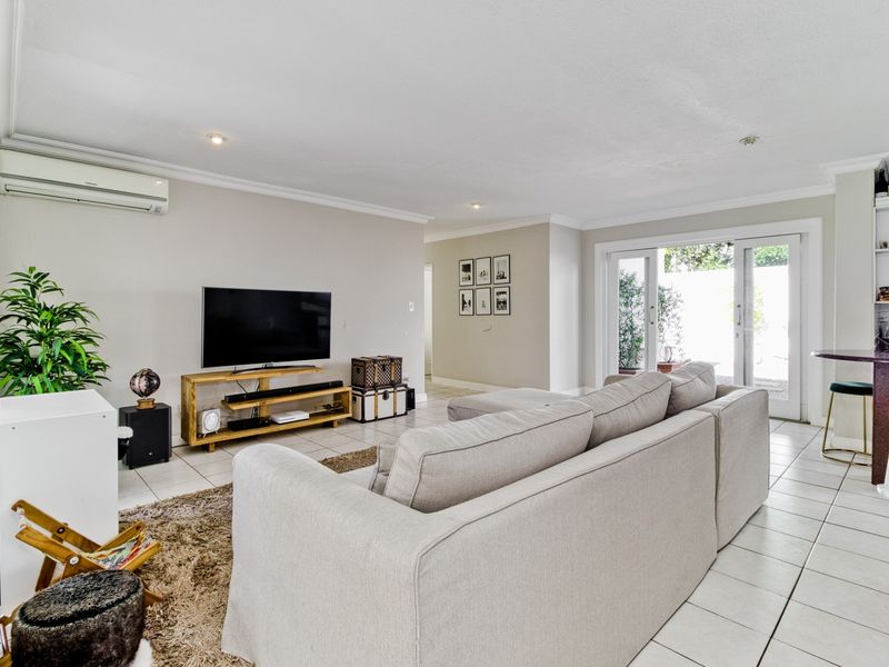 Spacious living area featuring tiled flooring, recessed lighting, and sliding glass doors providing access to the outdoor space.