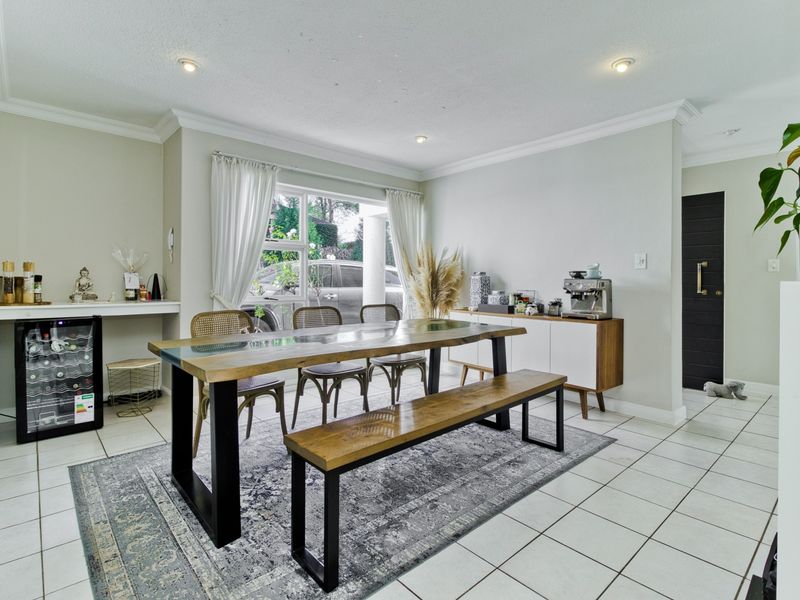 A bright and well-maintained dining room featuring tiled flooring, recessed downlighting, and a convenient built-in counter area.