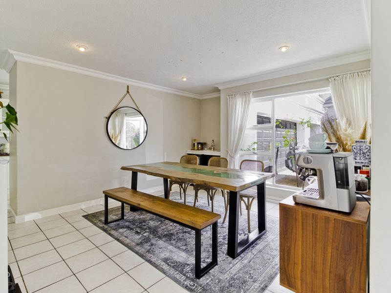 A bright dining area featuring tiled flooring, recessed downlighting, and large windows that provide ample natural light.
