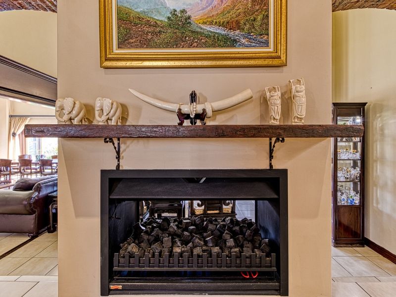 A central living area featuring a built-in fireplace with a rustic timber mantelpiece, framed by brick archways and finished with tiled flooring.
