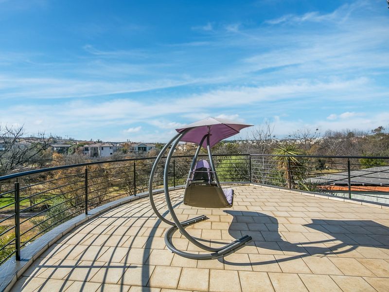 Spacious open-air balcony featuring tiled flooring and a secure metal balustrade, offering expansive views of the surrounding neighborhood.
