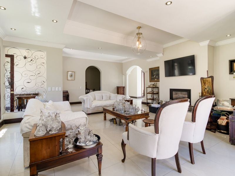 Spacious living room featuring tiled flooring, a built-in fireplace, recessed ceiling details, and elegant archways connecting to adjacent living areas.