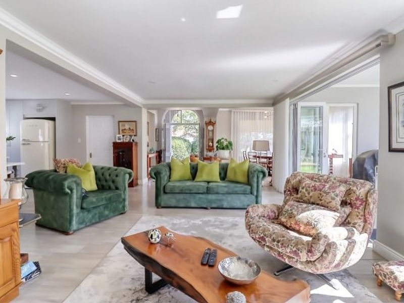 Spacious open-plan living area featuring neutral walls, recessed lighting, crown molding, and large sliding glass doors providing access to the outdoor space.