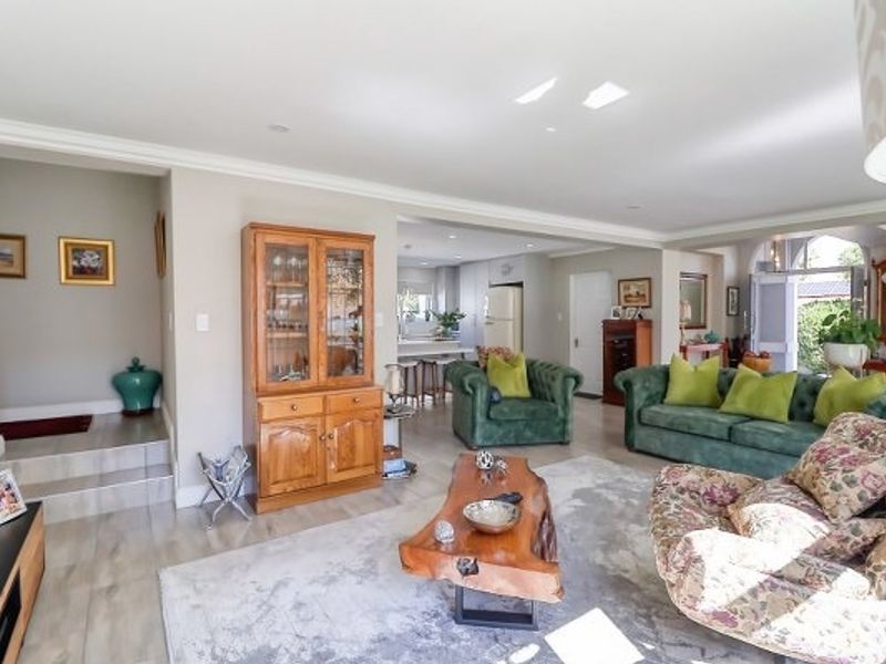 Spacious open-plan living area featuring tiled flooring, recessed lighting, and a seamless flow into the adjacent kitchen space.