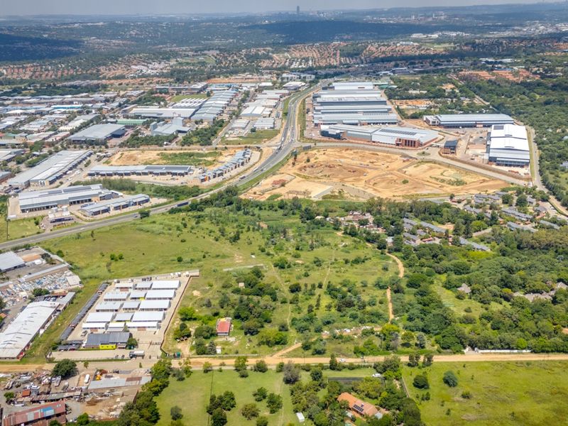 Aerial view of a large commercial vacant land plot situated within an established industrial and business development area.