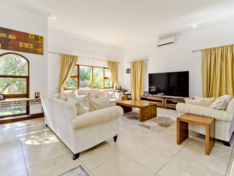 Spacious living room featuring large windows, tiled flooring, recessed lighting, and a wall-mounted air conditioning unit.