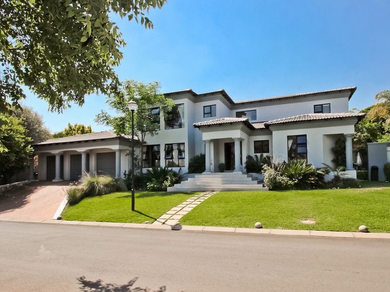 A well-maintained double-story residence featuring a triple garage, elegant columned entrance, and a manicured front lawn.