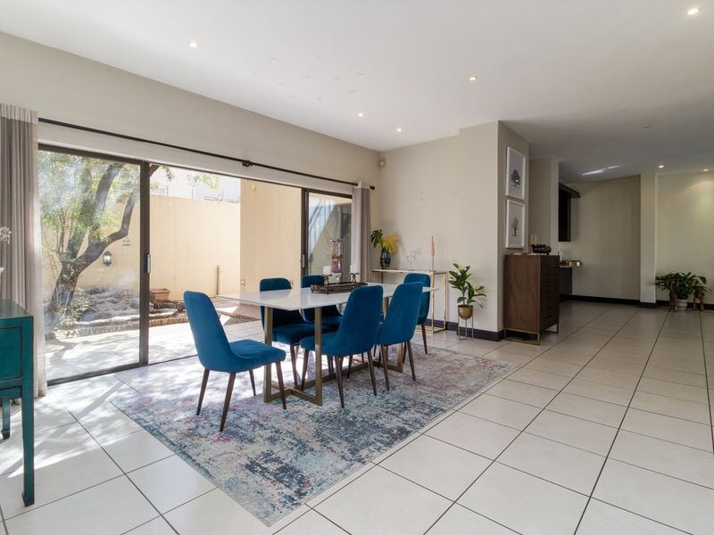 Open plan dining area featuring large sliding glass doors that provide seamless access to the outdoor patio and garden space.