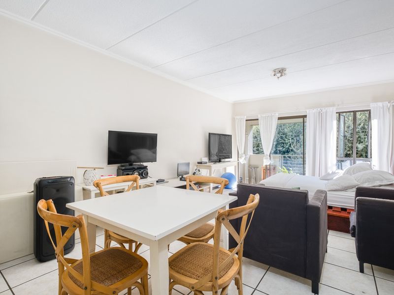 Open-plan living and sleeping area featuring tiled flooring and a sliding glass door providing access to an outdoor space.