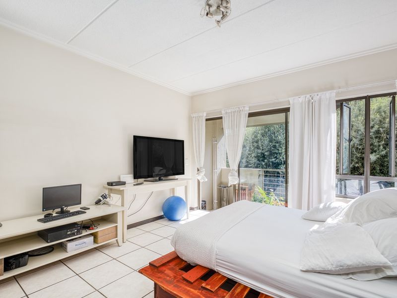 A bedroom featuring tiled flooring, a coved ceiling, and a sliding glass door providing access to an outdoor balcony area.