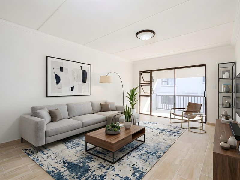 A bright and well-maintained living room featuring tiled flooring, a ceiling light fixture, and a sliding glass door providing access to a balcony.