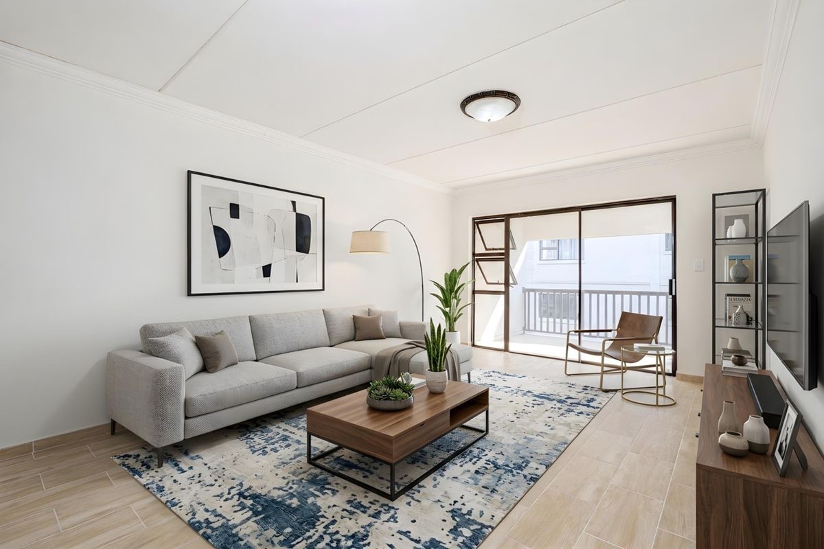 A bright and well-maintained living room featuring tiled flooring, a ceiling light fixture, and a sliding glass door providing access to a balcony.