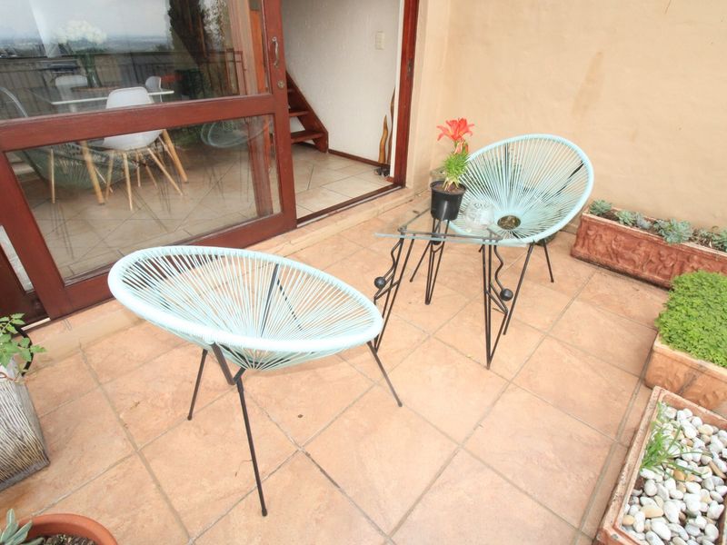 A tiled balcony area featuring a sliding glass door entrance, providing a functional outdoor space for relaxation.