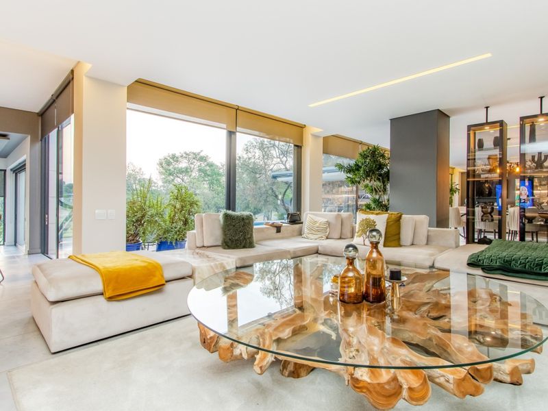 Spacious open-plan living area featuring large floor-to-ceiling windows, recessed lighting, and high-quality floor tiles, offering a bright and modern atmosphere.