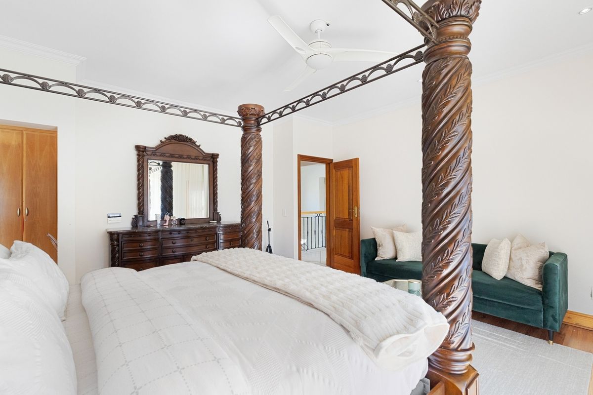 Spacious bedroom featuring a ceiling fan, built-in wardrobe, and classic timber door finishes.