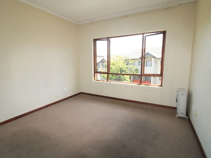 An empty bedroom featuring carpet flooring and timber-framed windows, offering a blank canvas for personalization and interior design updates.