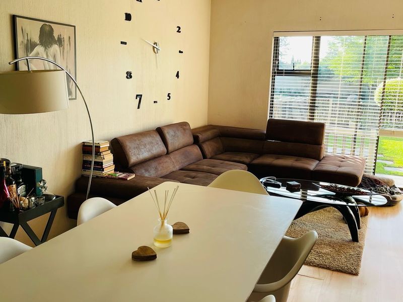 Open plan living and dining area featuring laminate flooring, track lighting, and a large sliding glass door providing access to the outdoor space.