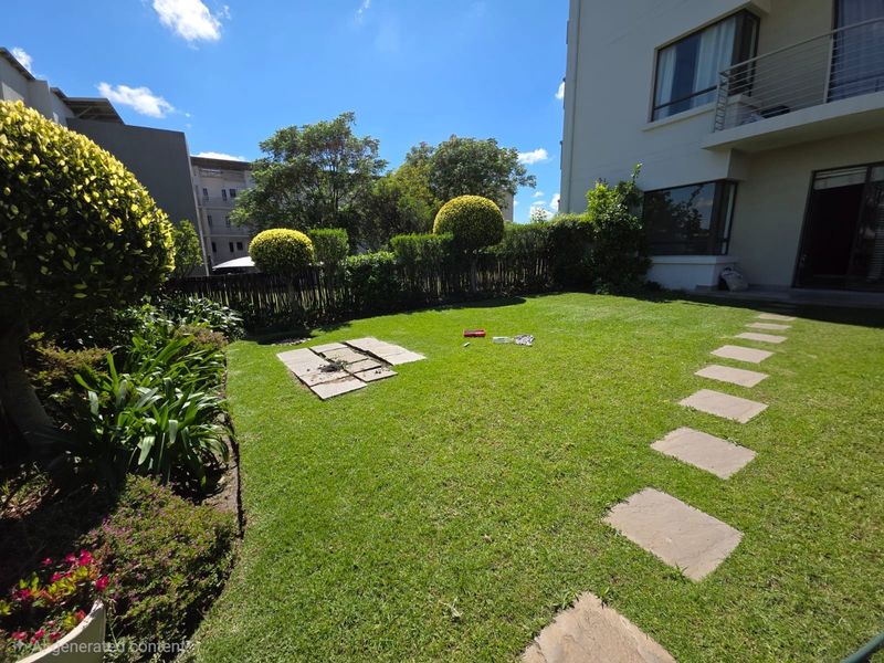 A private rear garden featuring a well-maintained lawn, stone paver pathways, and established perimeter hedging, adjacent to the apartment building.