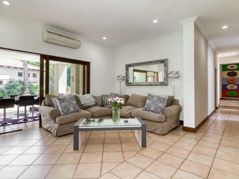 Spacious living room featuring tiled flooring, recessed lighting, and large sliding glass doors that provide seamless access to the outdoor patio area.