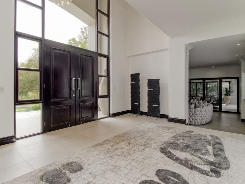 Spacious entrance hall featuring double doors, high ceilings, and large windows that provide ample natural light.