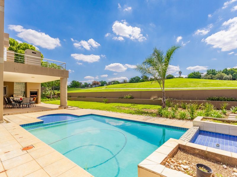 Outdoor entertainment area featuring a swimming pool, covered patio with built-in braai, and views overlooking the adjacent green space.