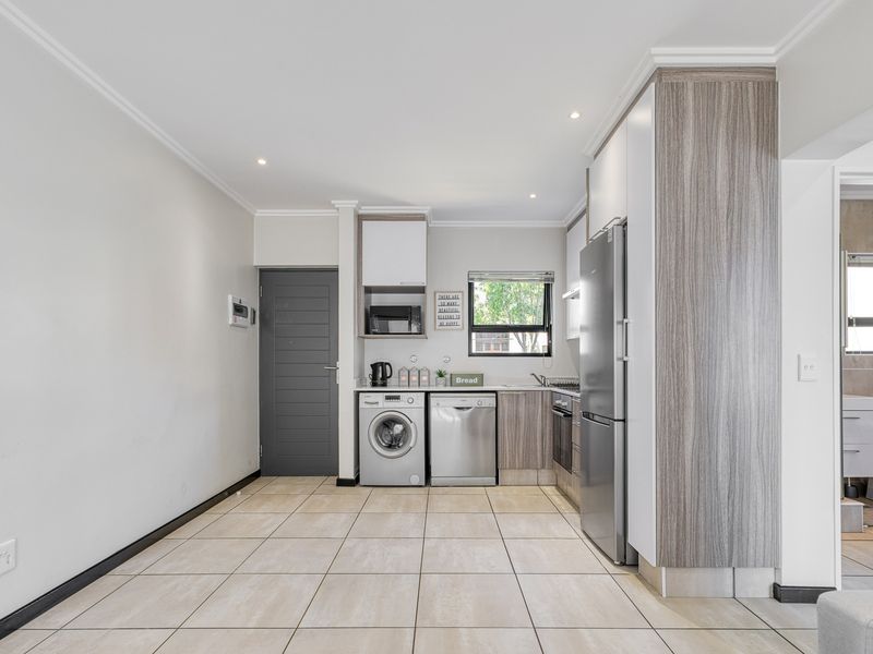 Modern kitchen featuring tiled flooring, built-in cabinetry, integrated appliances, and recessed lighting, with a clean and functional layout.