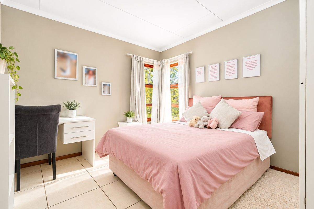 A well-maintained bedroom featuring neutral wall tones, tiled flooring, and corner windows that provide natural light.