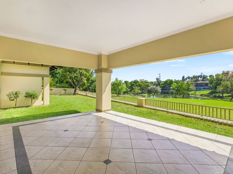 Spacious covered patio featuring tiled flooring and recessed lighting, offering direct access to the garden and scenic views of the surrounding estate.