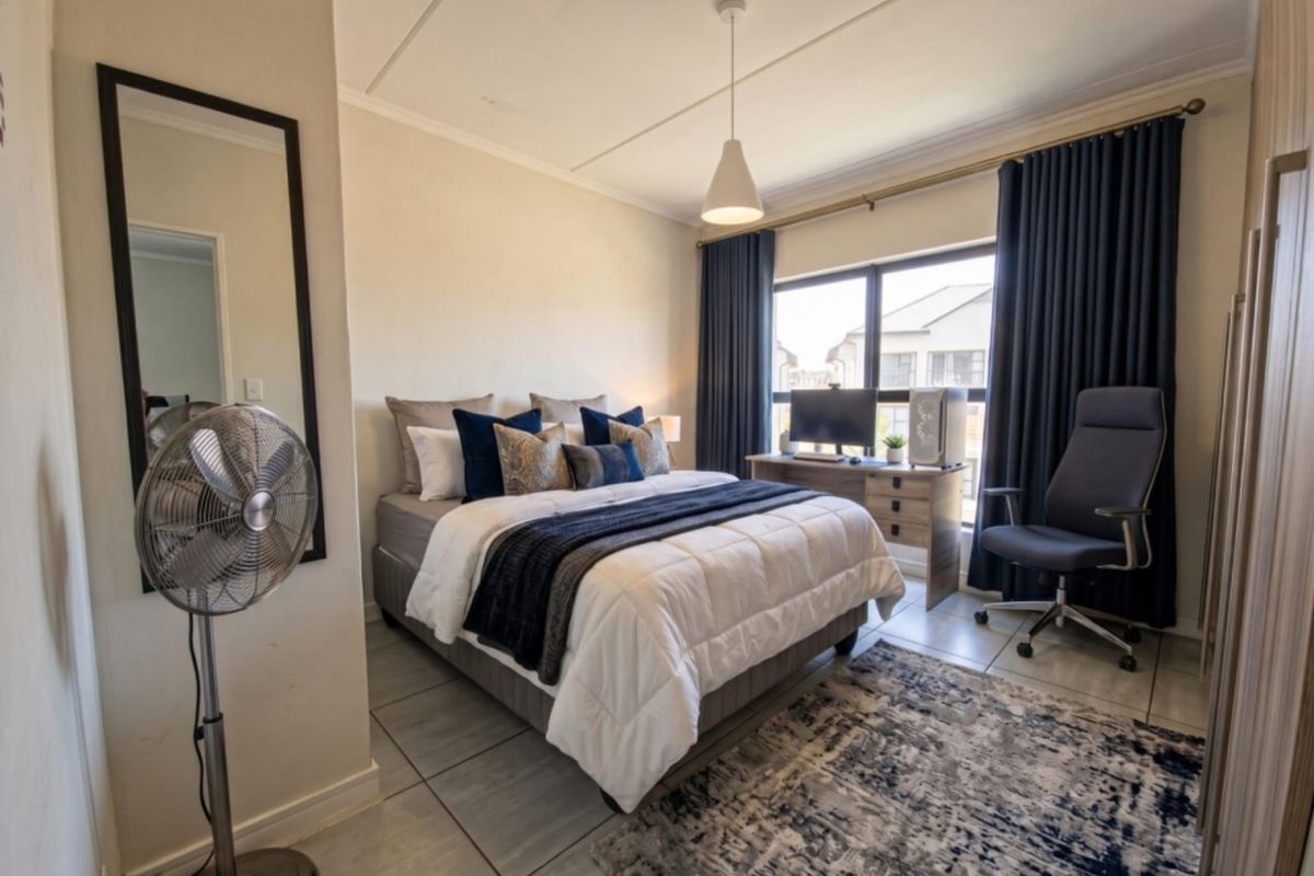 A well-maintained bedroom featuring tiled flooring, neutral walls, and a built-in wardrobe, offering a functional and comfortable living space.