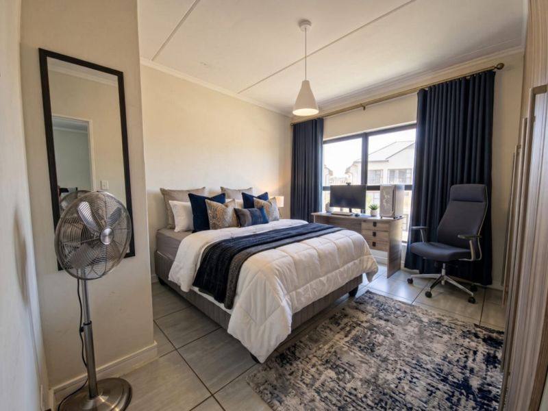 A well-maintained bedroom featuring tiled flooring, neutral walls, and a built-in wardrobe, offering a functional and comfortable living space.