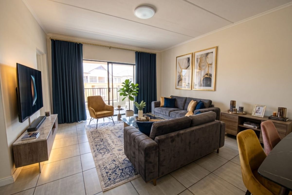 A well-maintained living room featuring tiled flooring and a large sliding glass door that provides access to an outdoor balcony area.