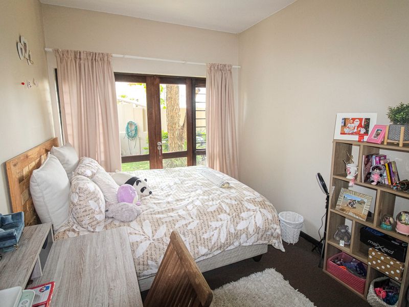 A cozy bedroom featuring carpeted flooring and a wooden framed glass door providing direct access to the exterior.